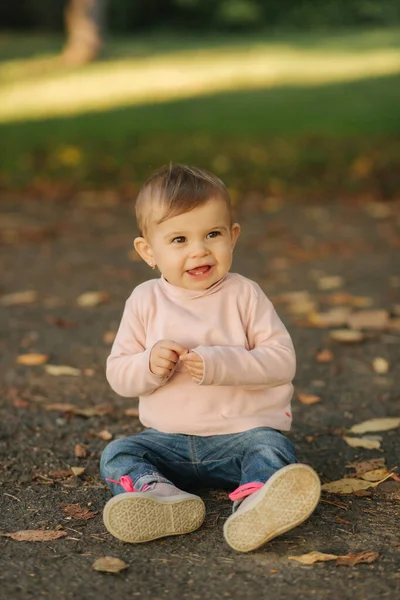 Primer plano de la hermosa niña sonriente. Niña feliz en el parque de otoño. Sonrisa de bebé de diez meses — Foto de Stock