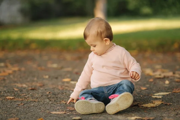 Primer plano de la hermosa niña sonriente. Niña feliz en el parque de otoño. Sonrisa de bebé de diez meses — Foto de Stock