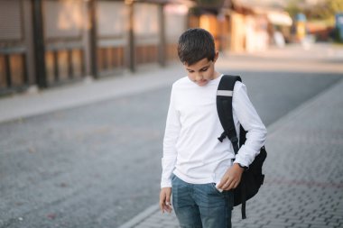 Genç çocuk cep telefonunun kablosuz kulaklığından aldı.