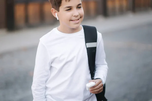 Хлопчик-підліток використовує бездротові навушники для прослуховування музики — стокове фото