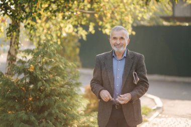 Yakışıklı son sınıf öğrencisi elinde gazeteyle parkta dolaşıyor. Sabahın erken saatlerinde parkta yürürken sakalını sakalına takmış.