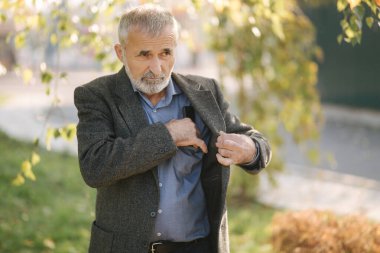 Yakışıklı sakallı yaşlı adam ceketinden bir akıllı telefon al.