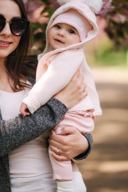 Anne ile dışında sevimli küçük kız bebek portresi. Güzel kız gülümsemesi. Beş aylık bebek. Mutlu aile