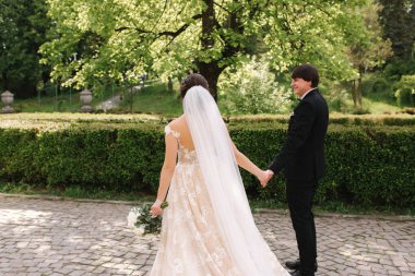 Damat ve gelin parkta büyük ağacın yanında duruyor