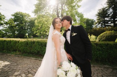 Damat ve gelin parkta büyük ağacın yanında duruyor