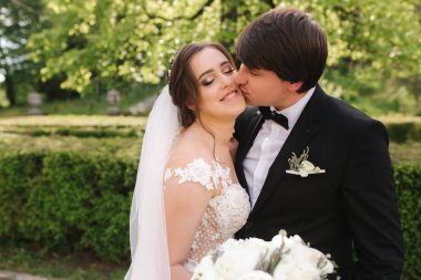 Mutlu damat ve gelin parkta yürüyor. Yakışıklı adam ile Büyüleyici kadın birlikte zaman geçirmek