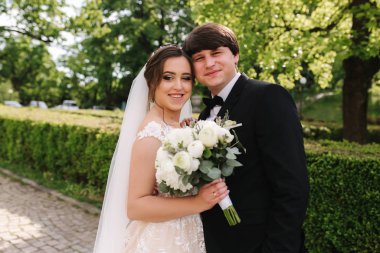 Mutlu damat ve gelin parkta yürüyor. Yakışıklı adam ile Büyüleyici kadın birlikte zaman geçirmek