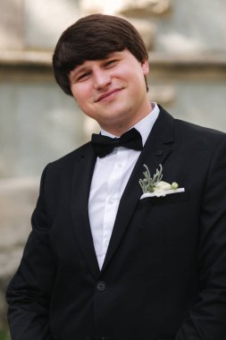 Siyah takım elbiseli yakışıklı damat merdivenlerden iniyor