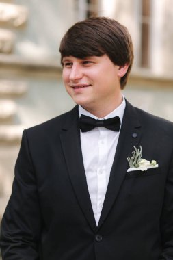 Siyah takım elbiseli yakışıklı damat merdivenlerden iniyor