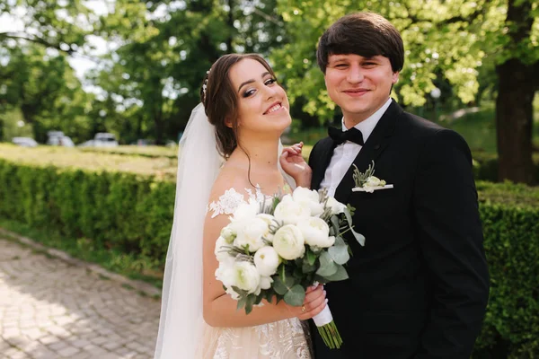 Gelukkige bruidegom en bruid wandelen in het Park. Charmante vrouw met knappe man tijd samen doorbrengen — Stockfoto