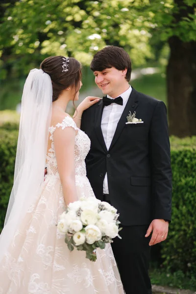 Gelukkige bruidegom en bruid wandelen in het Park. Charmante vrouw met knappe man tijd samen doorbrengen — Stockfoto