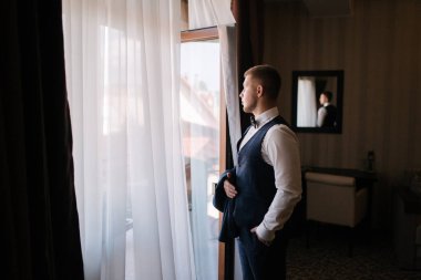 Otelde giyinmiş yakışıklı bir damat. Otelde sabah