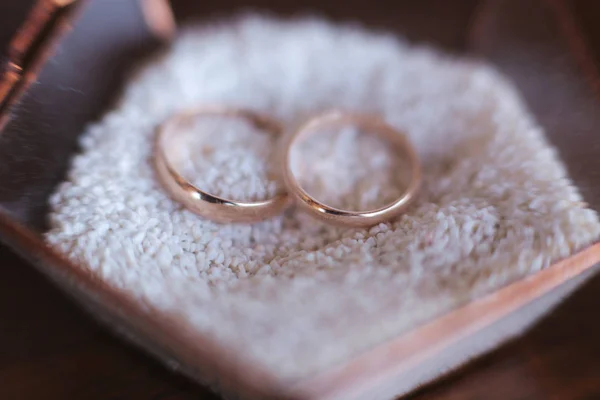 Svatební prsteny na písku. Zavřít zlaté prsteny — Stock fotografie