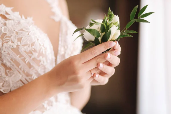 Close-up van de bruid vasthouden in handen boutonniere voor bruidegom — Stockfoto