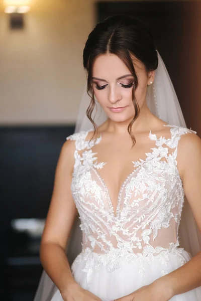 Primer plano retrato de la novia hermosa en el hotel por la mañana. Encantadora mujer con gran peinado y maquillaje — Foto de Stock