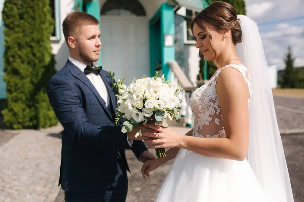 Primeiro olhar de noivo e noiva pela igreja — Fotografia de Stock