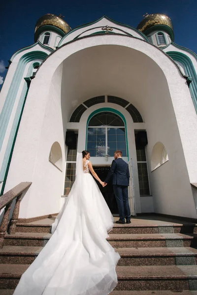 Primeiro olhar de noivo e noiva pela igreja — Fotografia de Stock