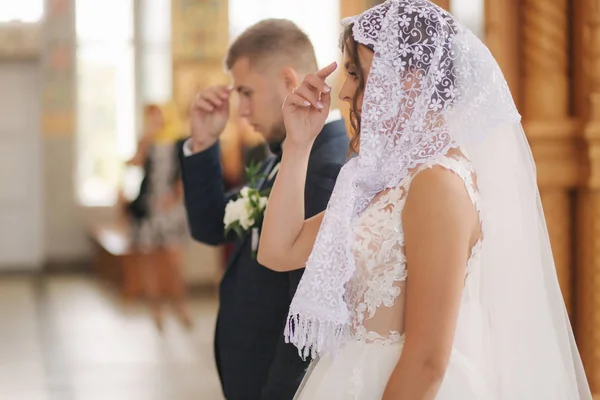 Pengantin pria dan pengantin wanita di gereja pada upacara pernikahan — Stok Foto