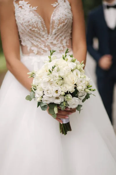 Νύφη κρατήσει γαμήλιο μπουκέτο από λουλούδια στα χέρια — Φωτογραφία Αρχείου