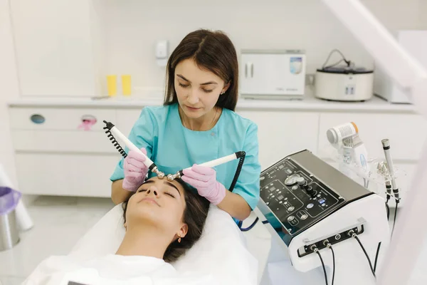Mujer joven tomando el procedimiento de belleza en el salón de spa. Electroforesis — Foto de Stock