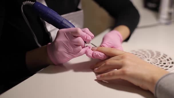 Taladro de uñas eléctrico en el salón de manicura. Primer plano de la manicura de hardware en un salón de belleza. La manicura femenina quita el gel viejo de las uñas de los clientes. Parrilla de aspiración — Vídeo de stock