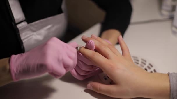 Profesjonalny manikiurzysta usuwa suchą skórę naskórka w pobliżu paznokci cięcia go nożyczkami. Zbliżenie wideo profesjonalnego manicure w salonie piękności — Wideo stockowe