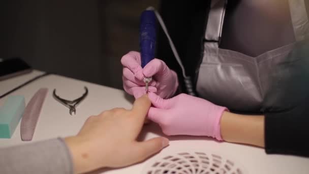 Electric nail drill in manicure salon. Closeup of Hardware manicure in a beauty salon. Female manicurist remove old gel from clients nails. Suction grill — Stock Video