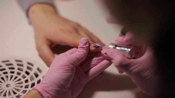 El primer plano de las mujeres pinta las uñas. Manicura arte de uñas. La mujer trabaja con guantes rosas. Primer plano de las manos de las mujeres — Vídeos de Stock