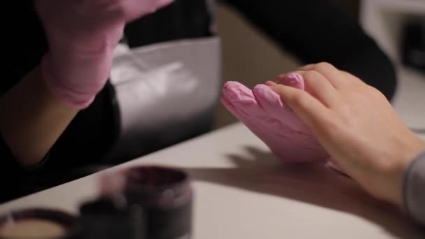 Nahaufnahme von Frauen, die Nägel lackieren. Maniküre Nagelkunst. Frau arbeitet in rosa Handschuhen. Nahaufnahme von Frauenhänden — Stockvideo