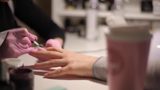 Primo piano del maestro unghie fa manicure professionale alla donna nel salone di cura delle unghie — Video Stock