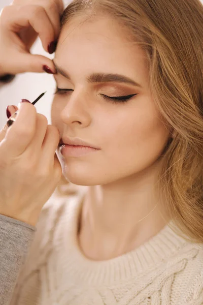 Modell haben ein Make-up von Visagistin im Schönheitssalon. Nahaufnahme von Models Gesicht mit Make-up — Stockfoto