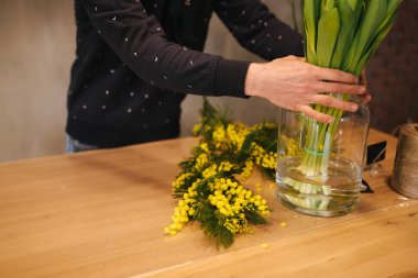 Çiçek buketi yapan adam. Sarı laleli bahar çiçeği.