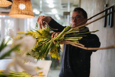 Çiçekçi bayram için buket yapar. Aile çiçek işi. Güzel bir çiçek kompozisyonu. Ayrıntılar. Kapat.