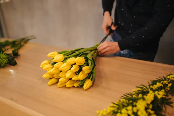 Hombre haciendo ramo de flores. Boquet amarillo primavera con tulipanes —  Fotos de Stock