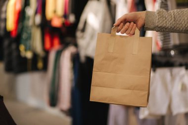 Giysi dükkanında el işi çantasıyla. Satın alınmış erkek el tepe torbası