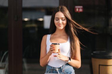 Şehrin merkezinde çekici bir esmer var. Güzel genç bayan dışarıda kahve içiyor.