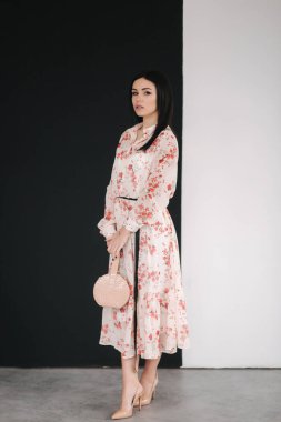 Genç esmer model. Stüdyoda bahar kıyafetlerini gösteriyor.