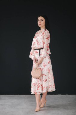 Genç esmer model. Stüdyoda bahar kıyafetlerini gösteriyor.