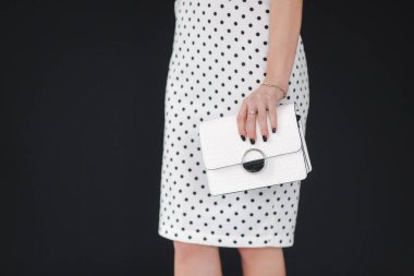 Beyaz bahar elbisesini gösteren güzel bir model. Siyah arka planda genç esmer