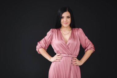 Bahar elbisesini gösteren güzel bir model. Siyah arka planda genç esmer
