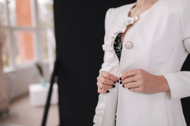 Stüdyoda siyah arka planda beyaz önlüklü esmer model.