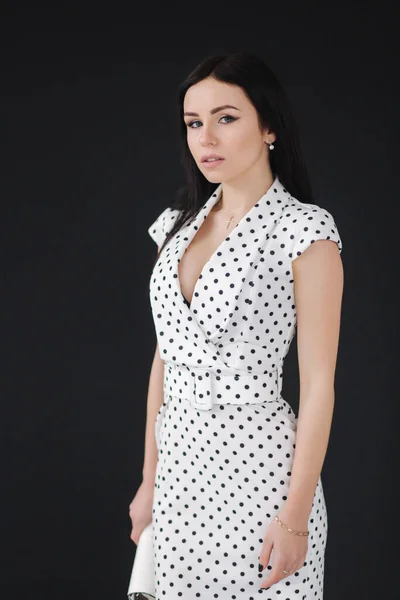 Vacker modell som visar vit vårklänning. ung brunett på svart bakgrund — Stockfoto