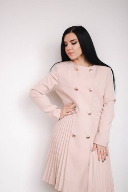 Stüdyoda bahar kıyafetlerini sergileyen güzel esmer kadın. Beyaz arkaplan