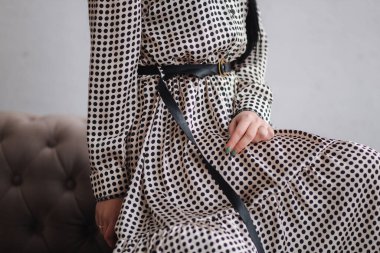 Kıyafetlerini gösteren çekici genç bir model. Zarif esmer kadın için bahar koleksiyonları. Güzel gri bahar elbisesi