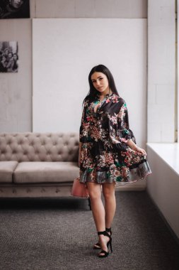 Kıyafetlerini gösteren çekici genç bir model. Zarif esmer kadının bahar koleksiyonları