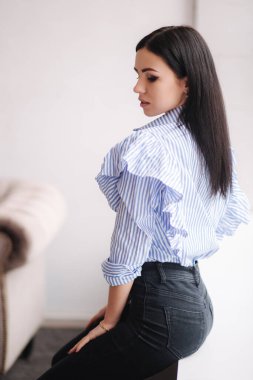 Kıyafetlerini gösteren çekici genç bir model. Zarif esmer kadın için bahar koleksiyonları. Demin biçimi