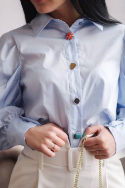 Kıyafetlerini gösteren çekici genç bir model. Zarif esmer kadın için bahar koleksiyonları. Mavi gömlek