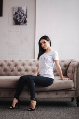 Kıyafetlerini gösteren çekici genç bir model. Zarif esmer kadının bahar koleksiyonları