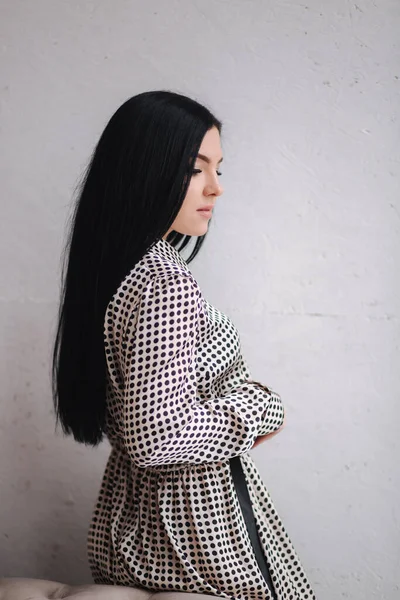 Modelo jovem atraente demonstrando roupas. Coleções de primavera em mulher morena elegante. Belo vestido de mola cinza — Fotografia de Stock