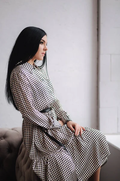 Modelo jovem atraente demonstrando roupas. Coleções de primavera em mulher morena elegante. Belo vestido de mola cinza — Fotografia de Stock